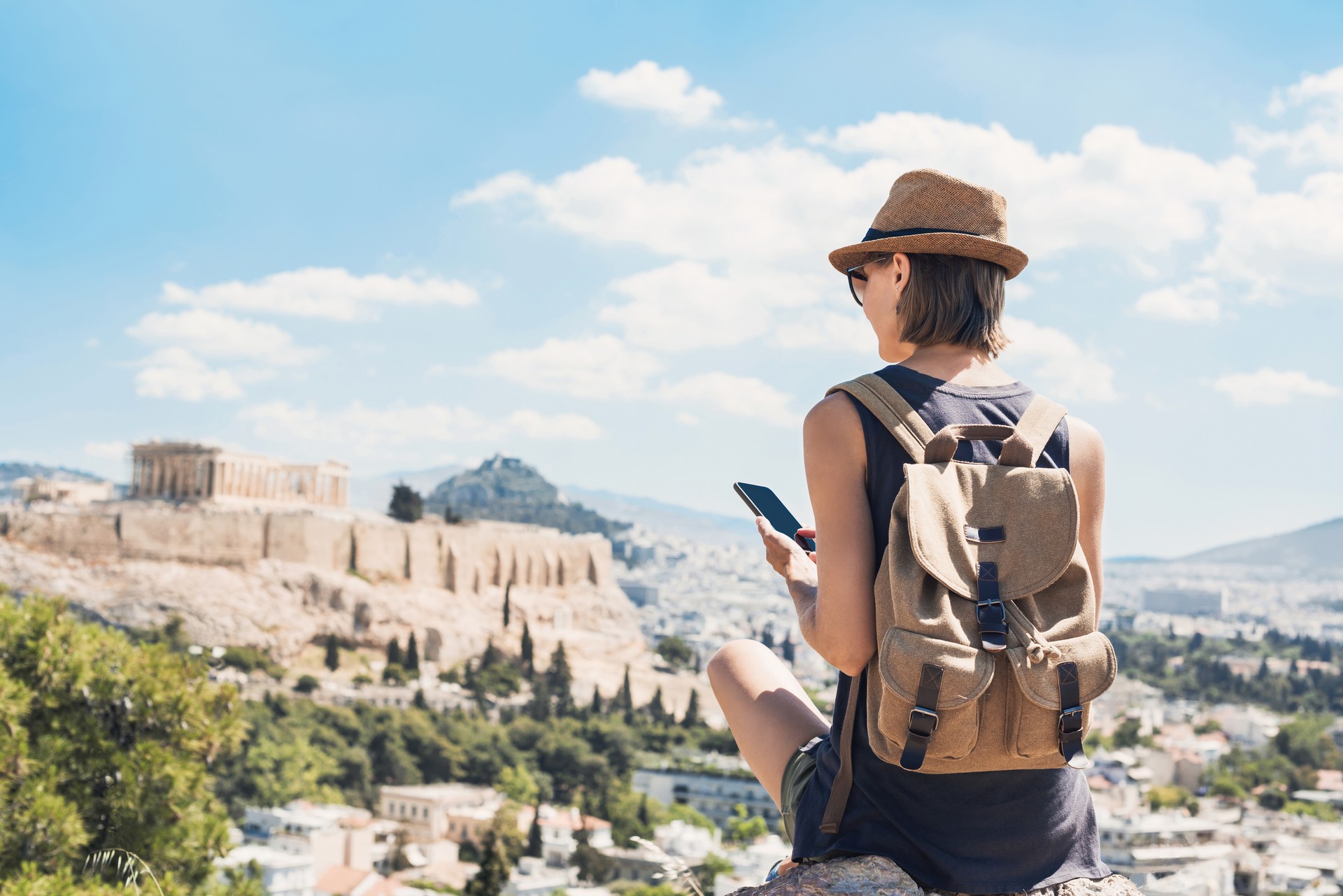 Woman using smart phone on vacations in Athens